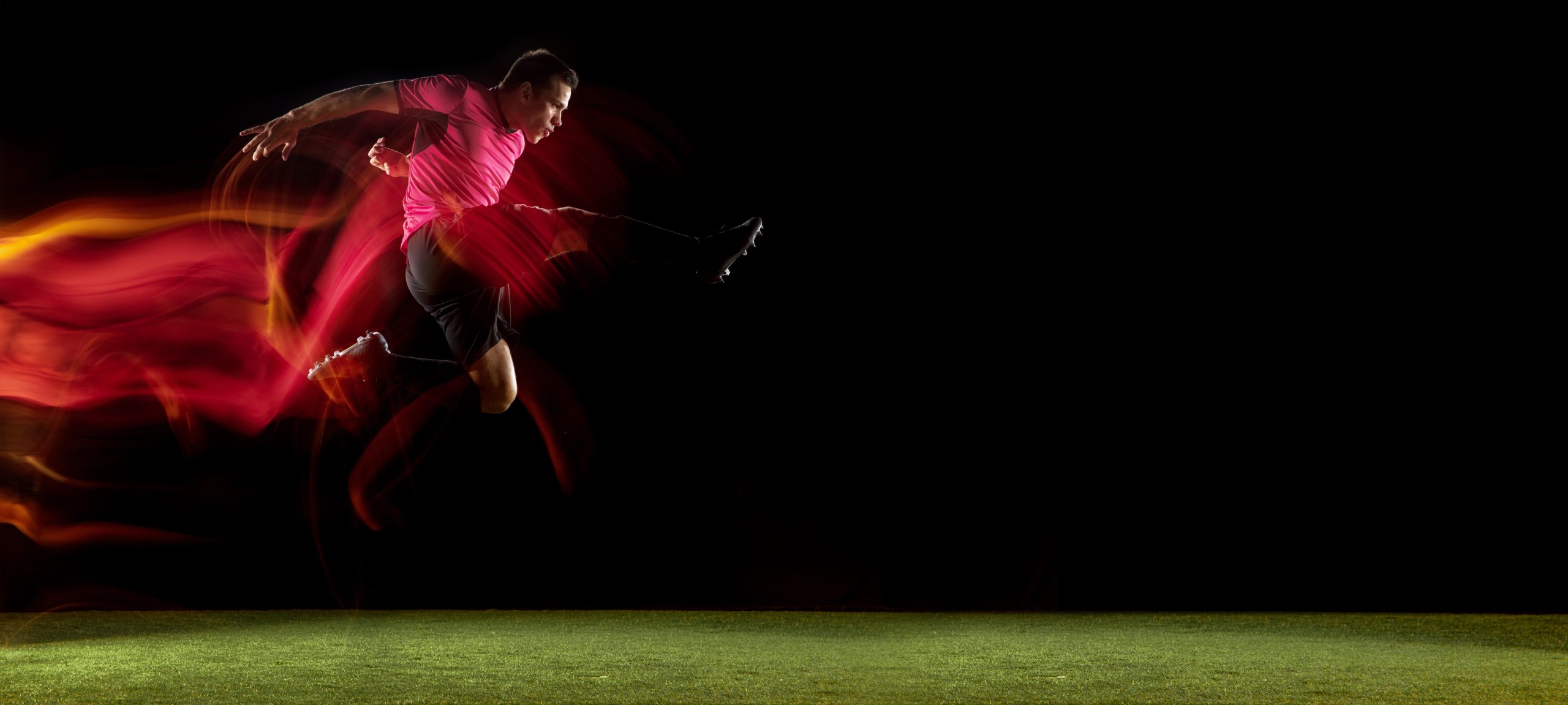 powerful,,flying,above,the,field.,young,football,,soccer,player,in