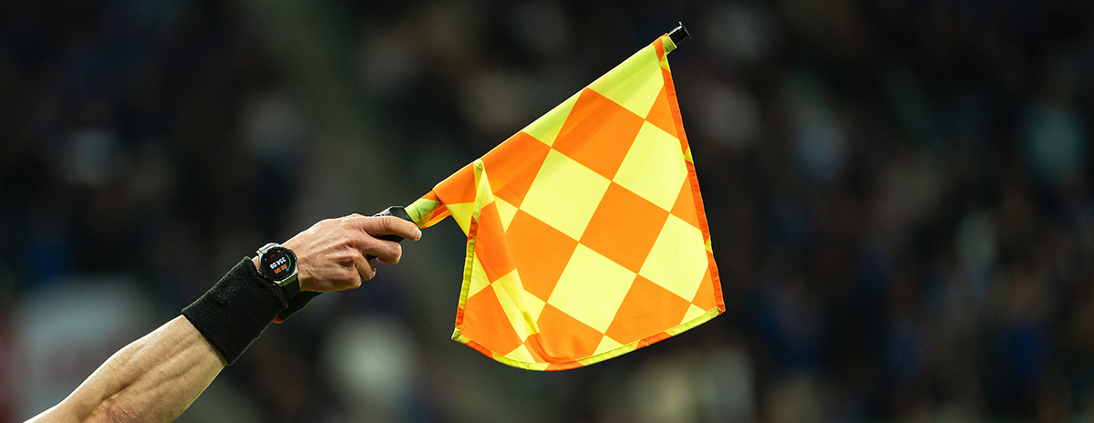raised,flag,in,the,hand,of,soccer,sideline,referee,during